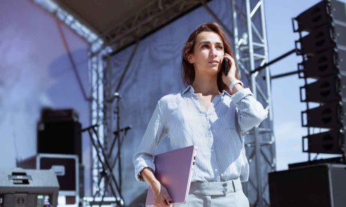 Junge Eventmanagerin telefoniert auf einem Event