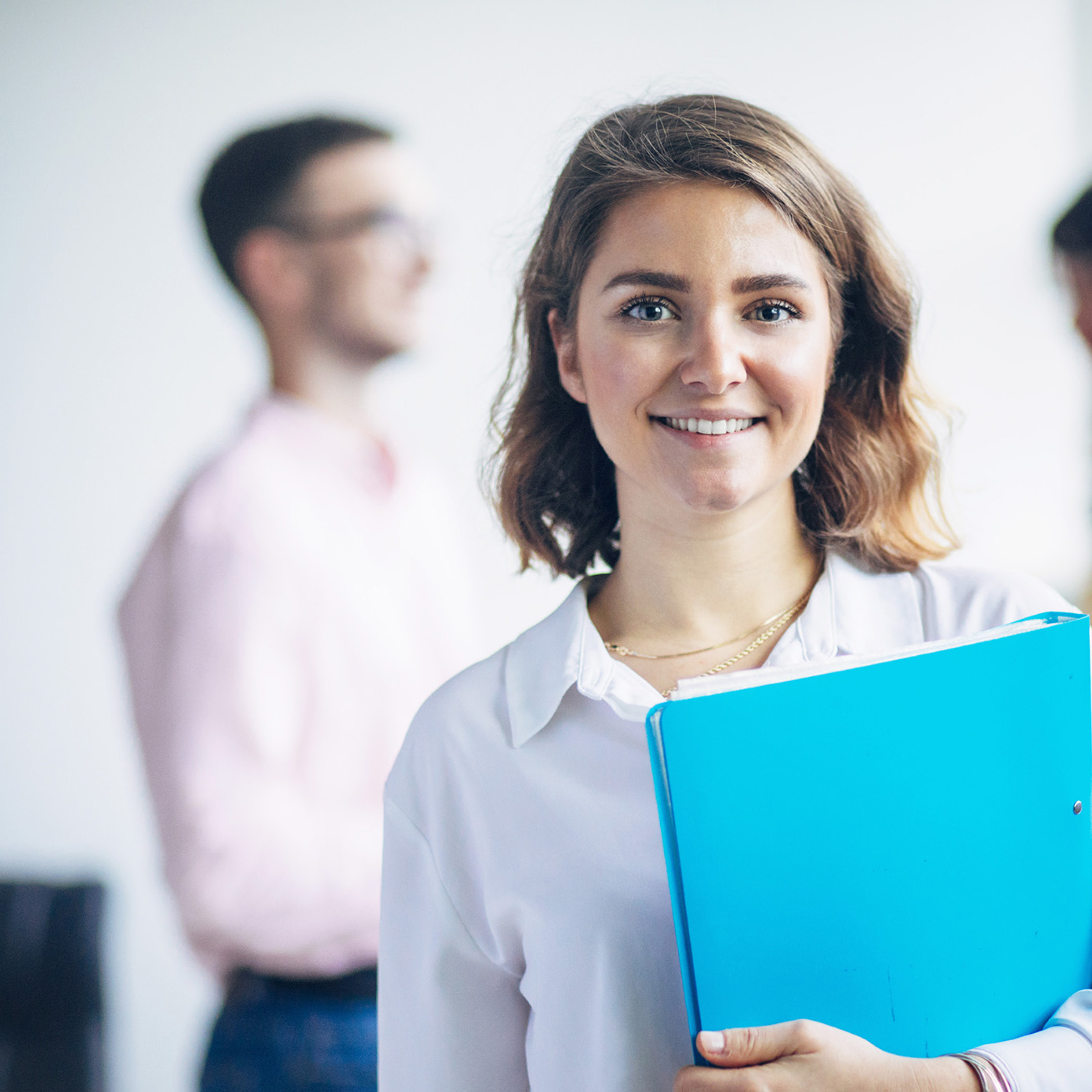Frau mit blauer Mappe lächelt in die Kamera