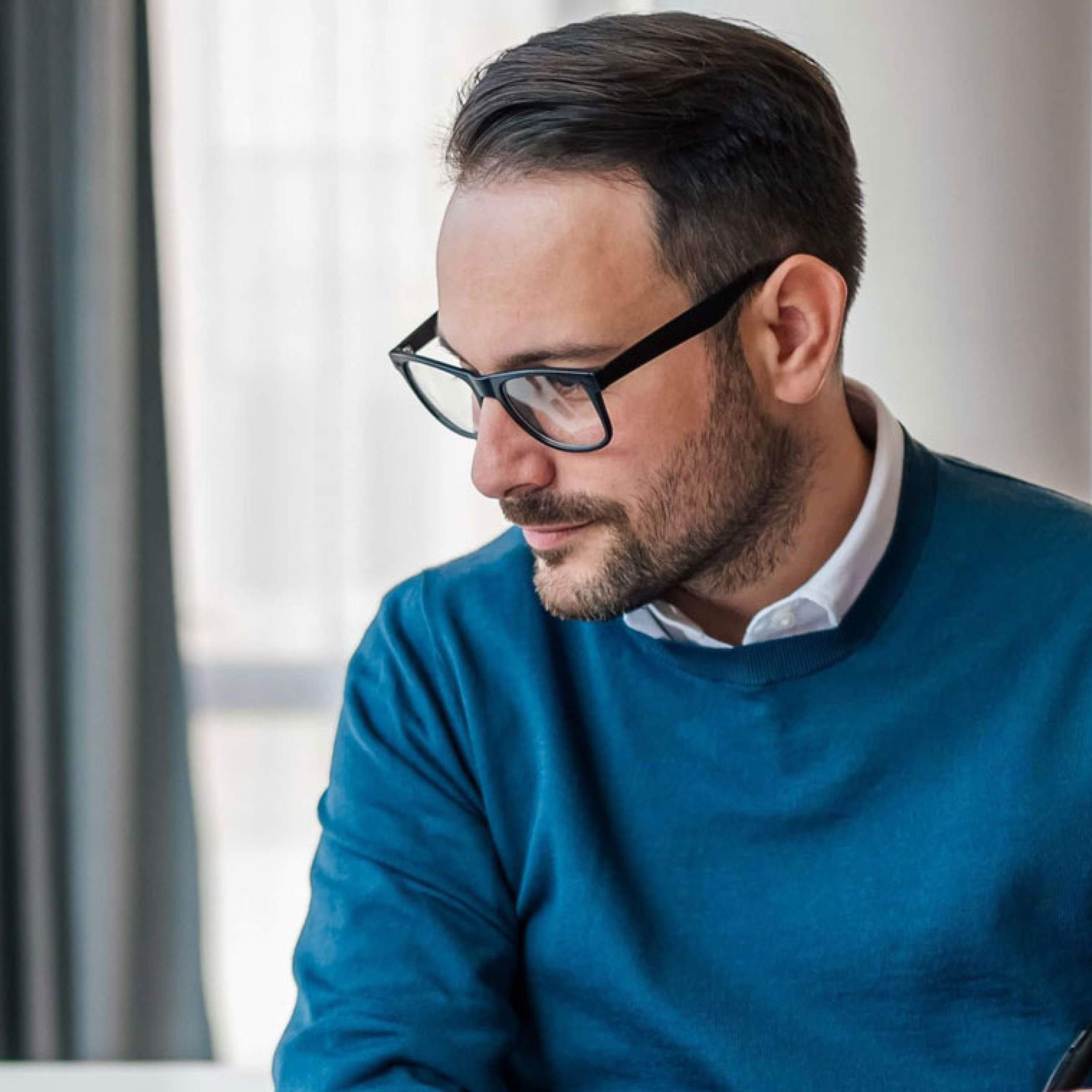 Mann arbeitet am PC und macht sich Notizen