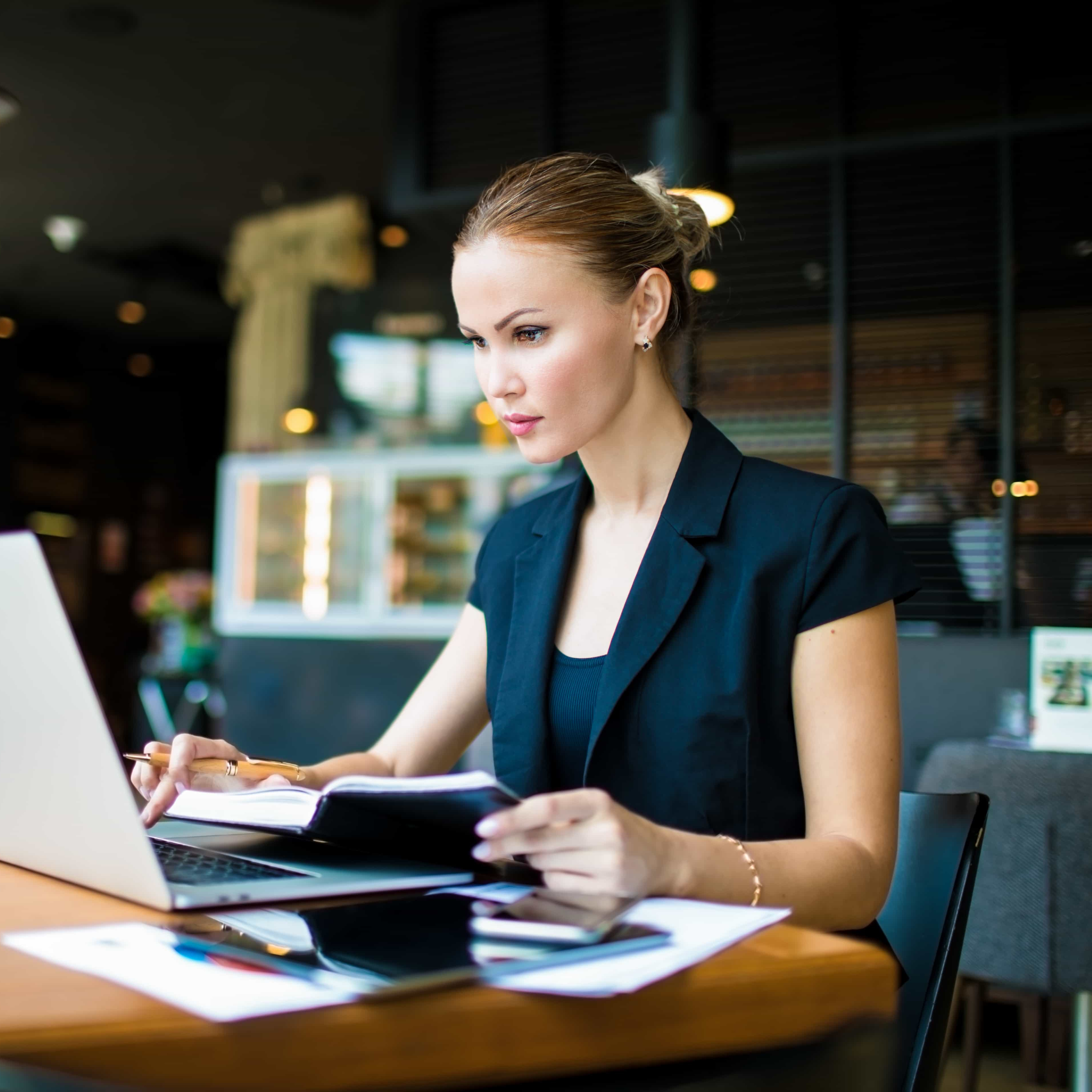 Frau sitzt in einem Cafe vor dem Laptop