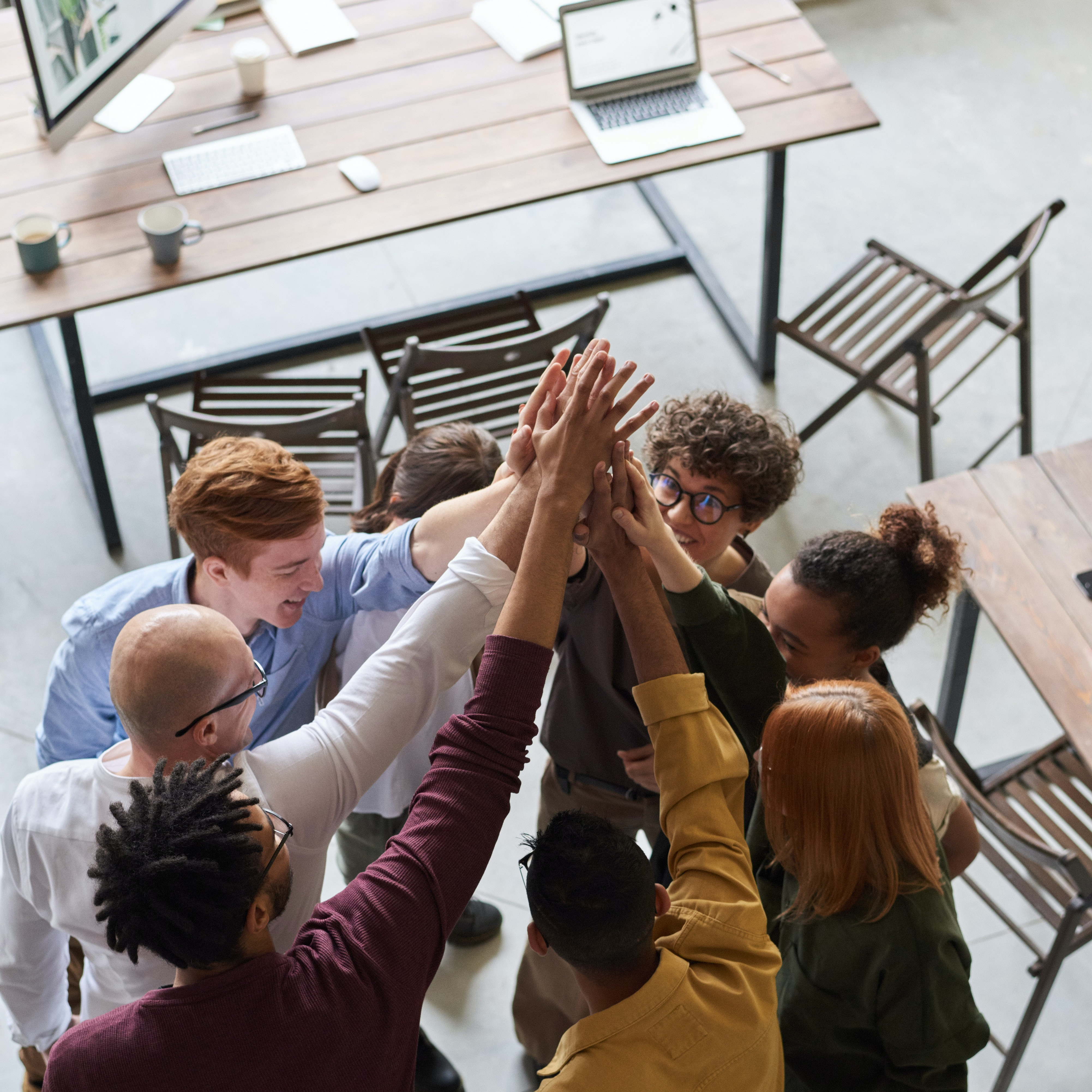 Männer und Frauen geben sich ein Gruppen-High-Five